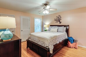 A bedroom with a bed, bedside tables, a lamp, a decorative wall piece, and a ceiling fan. - 3 Mi to Assateague Beach! Home w/ Furnished Deck (Chincoteague)