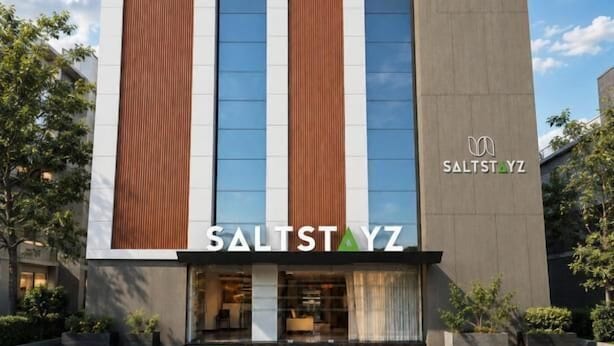 Un edificio moderno con un logotipo destacado que dice 'SALTSTAYZ' en la entrada.