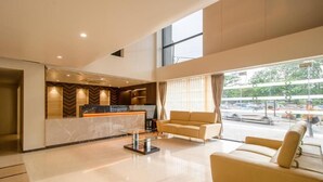 A hotel lobby with a reception desk, a sofa, and a coffee table.