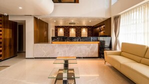 Un interior moderno con una isla de cocina central, un sofá y una mesa de centro de vidrio.