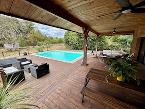 A wooden deck with outdoor furniture, a swimming pool, and a covered area with ceiling fans. - Villa with pool, sleeps 8, 4,500 m² garden, Bordeaux (Latresne)