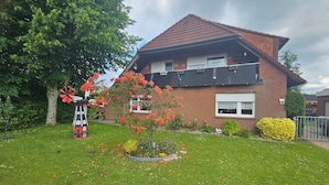 A two-story house with a brick exterior and a red-tiled roof.