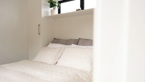 A bed with a white bedspread and multiple pillows.