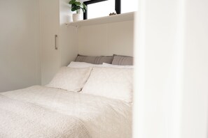 A bed with a white bedspread and multiple pillows.