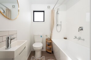 Un baño moderno con inodoro, lavabo y bañera.