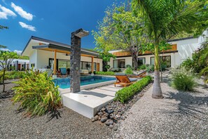 A modern house with a swimming pool, outdoor seating, and a well-maintained garden. - Tamarindo Compound w/ Pools & Stunning Views (Tamarindo)