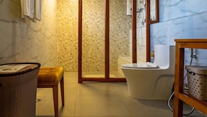 A bathroom with a shower, toilet, and a small seating area. - Metta Resort & Spa (Paro)