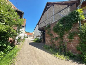 Un stretto vicolo acciottolato con edifici su entrambi i lati, alcuni con mattoni a vista e altri con facciate in legno.