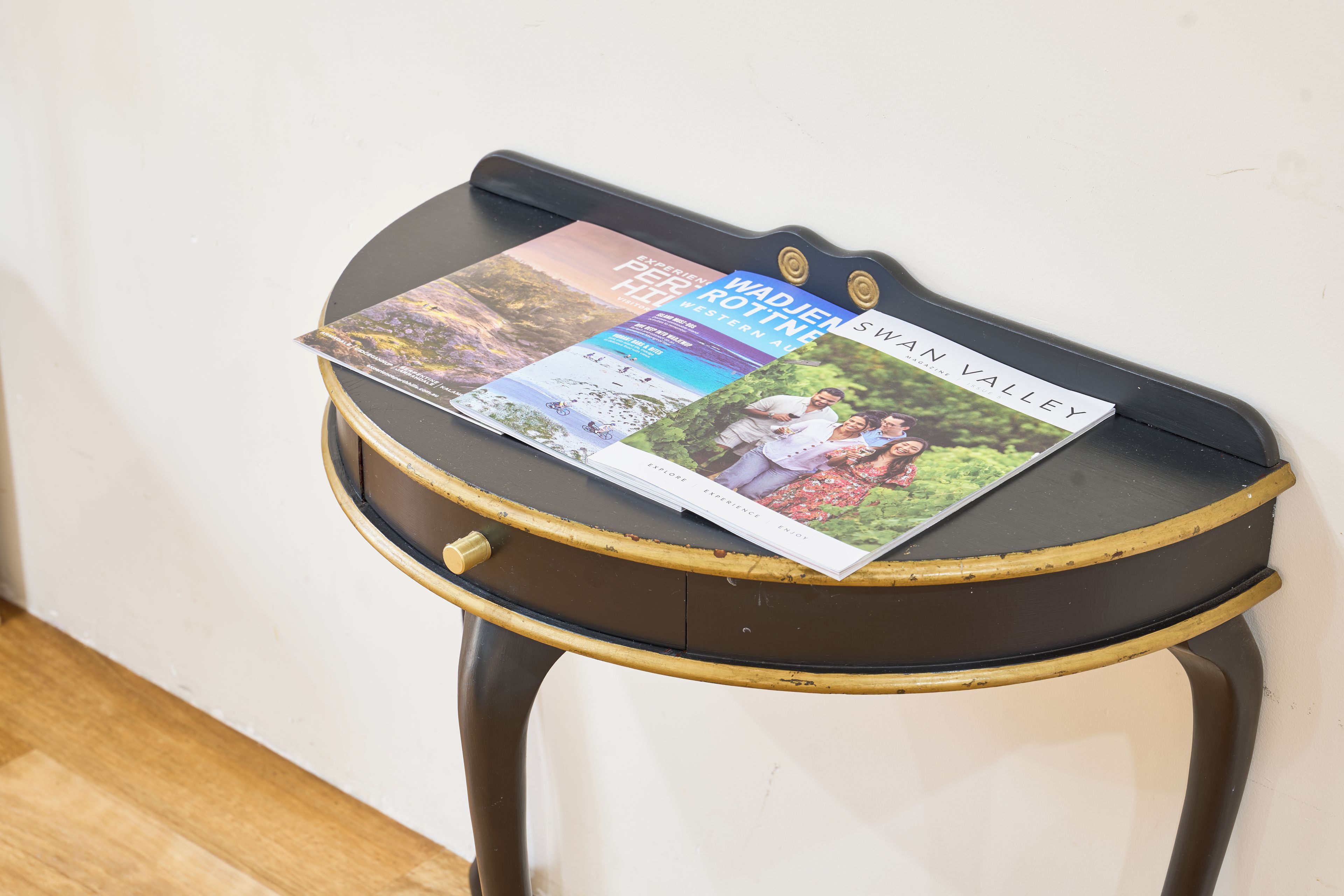 Une petite table ronde sur laquelle est posé un magazine.
