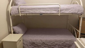 A bunk bed with a lower bed and a nightstand.