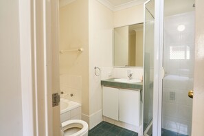 A bathroom with a toilet, sink, and shower area. - Villa Woody - Your Home Away from Home (Woodbridge)