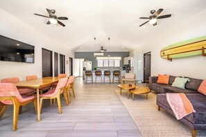 A spacious living area with a dining table, sofas, and a kitchen in the background. - Avellanas Beach Condo: Saltwater Pool Access! (Playa Avellanas)