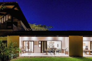 A modern house with a spacious patio, a dining area, and a kitchen. - Tamarindo Villa w/ Pool & Beach Club Access (Tamarindo)