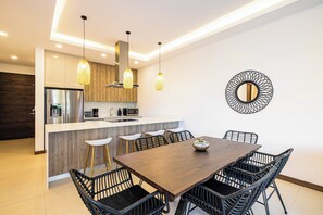 A modern kitchen with a central island, stainless steel appliances, and pendant lighting. - Tamarindo Villa w/ Pool & Beach Club Access (Tamarindo)