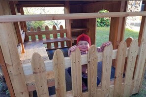 A wooden play structure with a bench and a fence. - Holiday apartment with 2 bedrooms (Kölpinsee)