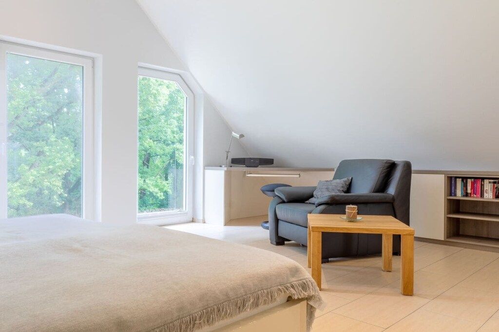 Un dormitorio con una cama grande, un escritorio, una silla y una estantería.