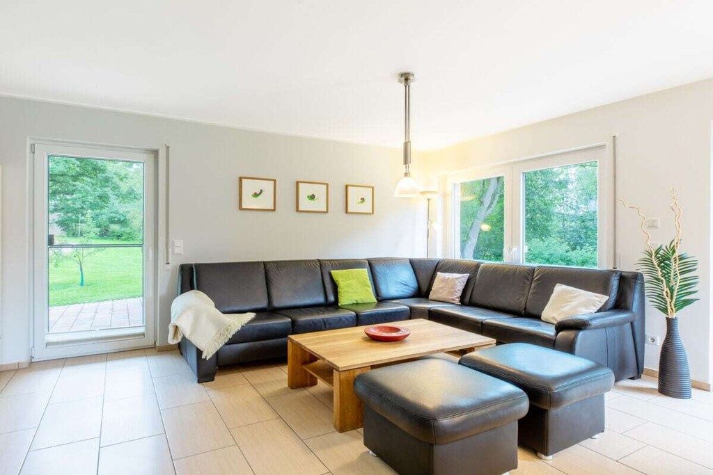 Una sala de estar moderna con un sofá modular, una mesa de centro y una planta en maceta.