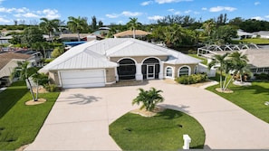 A residential house with a garage, a driveway, and a well-maintained lawn. - Almare Gulf Access Pool Spa Boat Dock (Cape Coral)