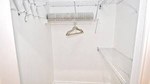 A white closet with a hanging rack and a metal shelf. - Almare Gulf Access Pool Spa Boat Dock (Cape Coral)