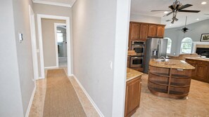 A kitchen with wooden cabinets, stainless steel appliances, and a granite countertop. - Almare Gulf Access Pool Spa Boat Dock (Cape Coral)