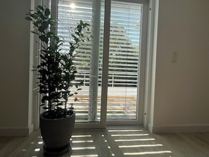 Ein Zimmer mit einer Zimmerpflanze neben einer Schiebetür.
