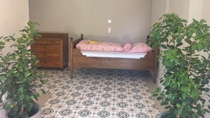 A bedroom with a wooden bed, a dresser, and two potted plants. - Open, Bright Apartment (Halle (Westfalen))