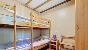 A bunk bed room with a desk and chair.