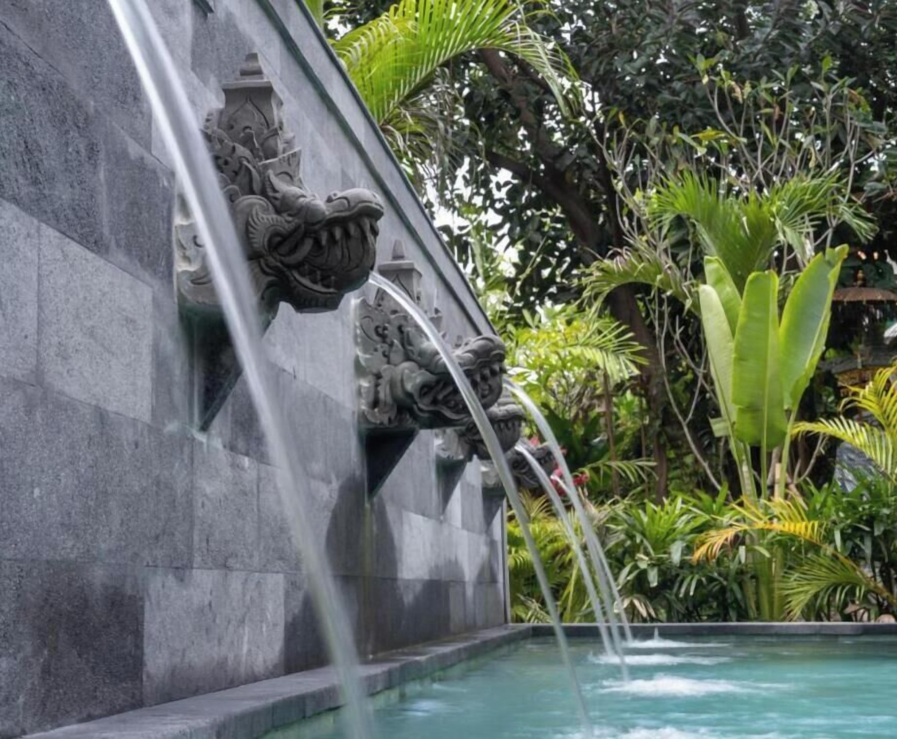 Ein Wasserspiel mit einer Drachenskulptur und einem Becken.