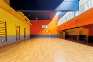 An indoor basketball court with a wooden floor, a basketball hoop, and a net. - Rooftop & Pool - Secure Parking (Paris)