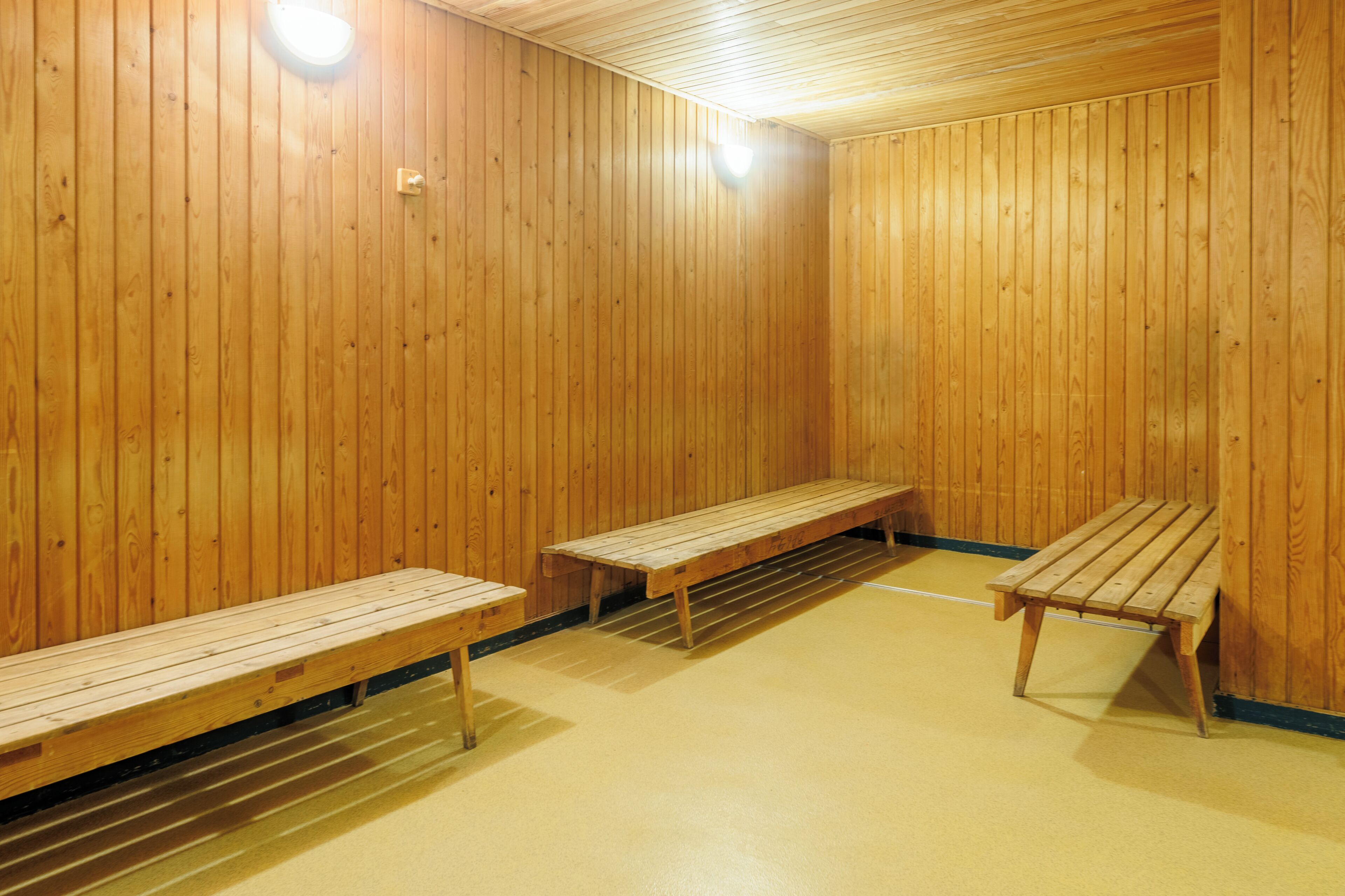 Un sauna con bancos de madera y un banco con respaldo.