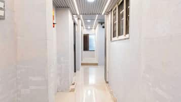 A corridor with a shiny floor, white walls, and a metal ceiling.