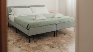 A bedroom with a bed, a nightstand, a lamp, and a window with curtains. - A cozy home for families and friends, just a stone's throw from the Vatican. (Roma)