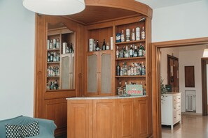 Una zona de bar con armarios y estantes de madera repletos de diversas botellas de licor.