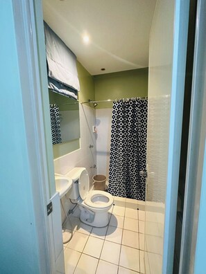 A bathroom with a toilet, a shower, and a sink. - Charming 3-bedroom House Rental in Guarded Cagayan de Oro Suburb (Cagayan de Oro)