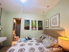 A bedroom with a bed, a bedside table, a lamp, and a wall with three framed pictures. - Charming 3-bedroom House Rental in Guarded Cagayan de Oro Suburb (Cagayan de Oro)
