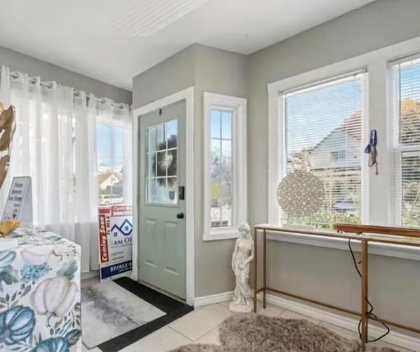 A room with a door, a window, a statue, and a table with a placard.