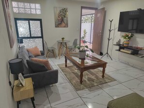 A living room with a sofa, coffee table, and TV. - The best location in the south—let us pamper you. (Ciudad de México)