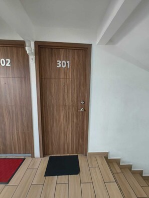 A hotel entrance with two wooden doors labeled '02' and '301' and a black mat at the bottom. - The best location in the south—let us pamper you. (Ciudad de México)