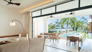 A modern hotel room with a large window, a pool, and a dining area. - 2-Bed Ocean View on Beach • Sol de Arena C5 (Las Terrenas)