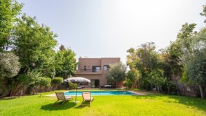 A modern two-story house with a swimming pool, surrounded by lush greenery. - Riad Garden Targa Pool (Marrakech)