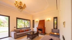 A modern living room with a fireplace, sofas, and a coffee table. - Riad Garden Targa Pool (Marrakech)