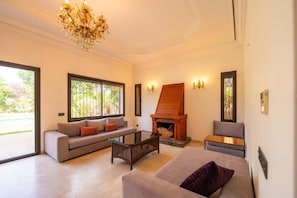 Ein modernes Wohnzimmer mit Kamin, Sofas und einem Couchtisch.