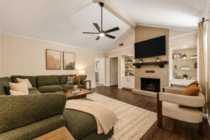 A living room with a sofa, coffee table, and a fireplace. - Sleeps 14 ~ MiniGolf, HotTub, MovieRm, Sauna, Firepit (Columbus)
