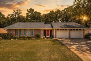 A single-story house with a brick facade, a red front door, and a garage with two doors. - Sleeps 14 ~ MiniGolf, HotTub, MovieRm, Sauna, Firepit (Columbus)