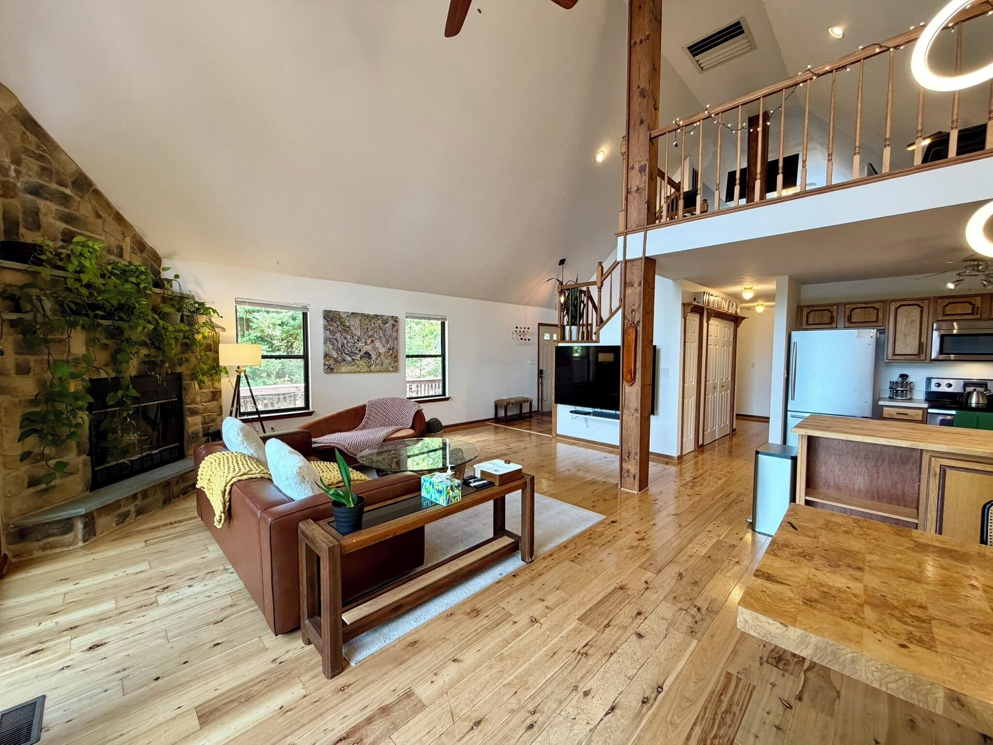 Uma sala de estar ampla com lareira, área de refeições e cozinha.
