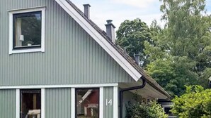 Ein zweistöckiges Haus mit grauer Fassade, weißen Verzierungen und der deutlich sichtbaren Hausnummer 14.