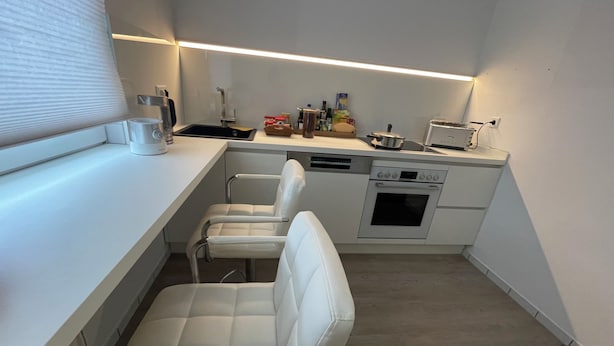 Una cocina compacta con horno integrado, lavavajillas y una pequeña superficie de encimera.