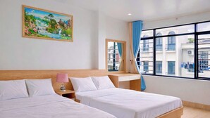 Habitación de hotel con dos camas, una mesita de noche, una lámpara, una ventana con cortinas y un cuadro en la pared.