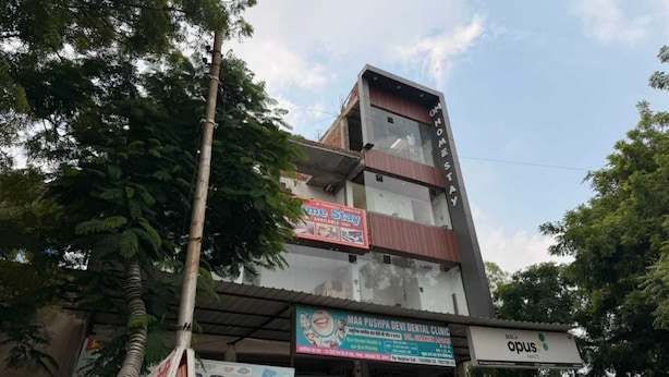 A multi-story building with various signs, including a dental clinic and a paint store. - Om Home Stay (Agra)