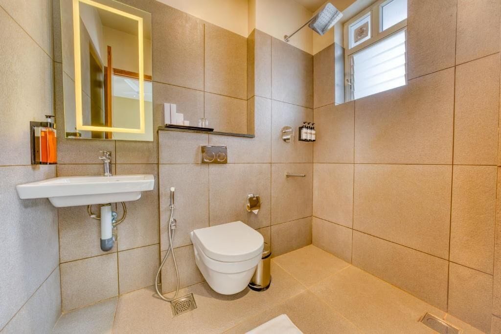A modern bathroom with a sink, toilet, and shower.